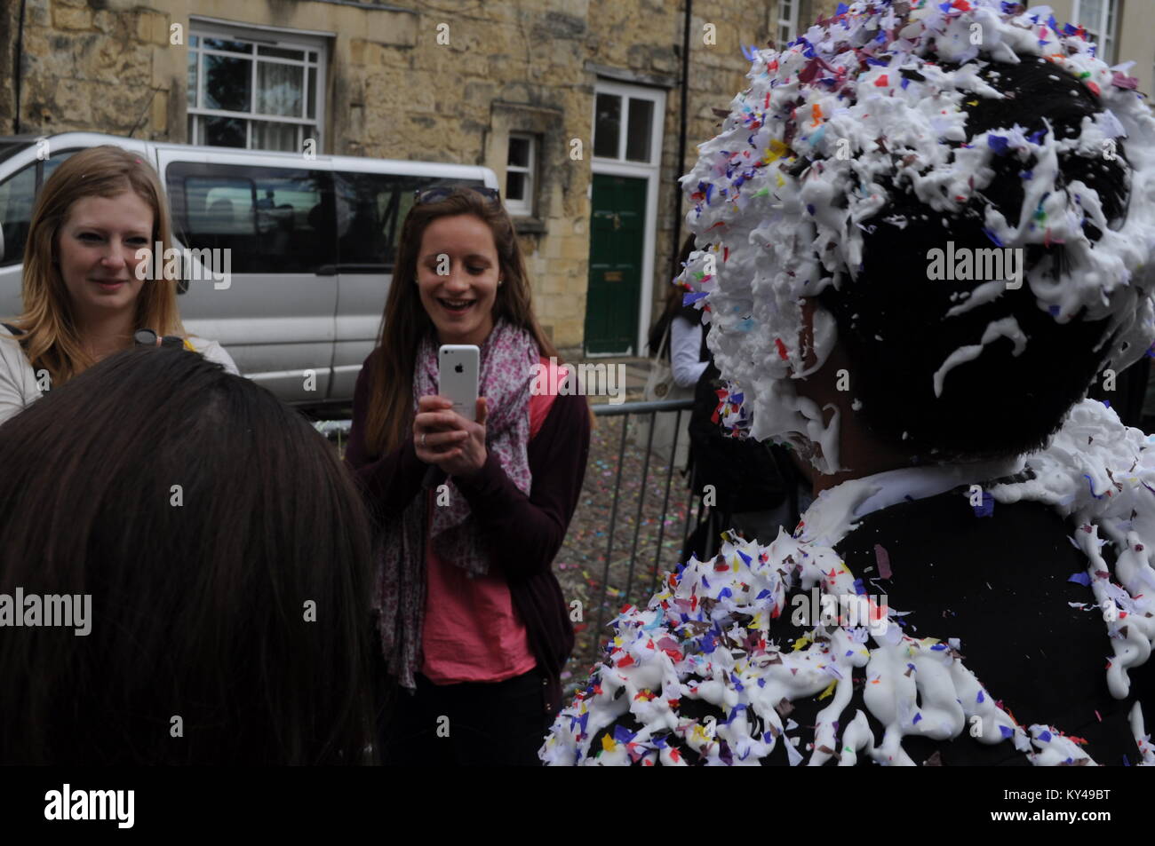 Students leaving their last exam meet friends for a traditional 'trashing' at the back of Oxford University Examination School, Oxford, England, UK. Stock Photo