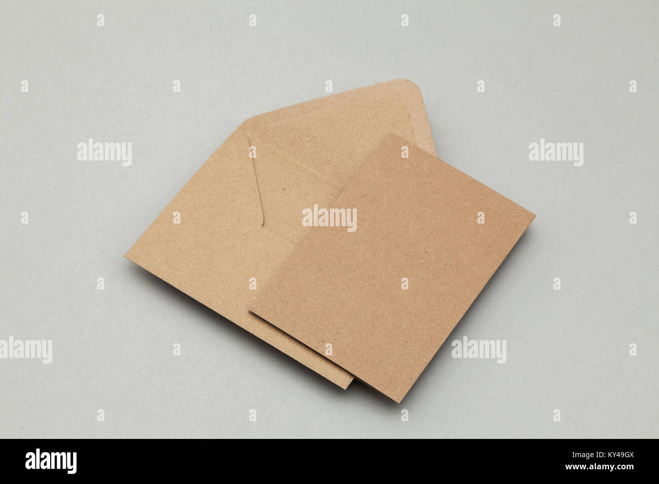 Blank brown kraft paper card and envelope on a grey background Stock Photo
