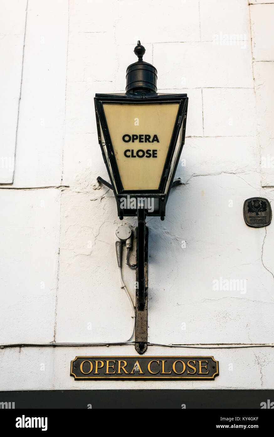 Close up of old Victorian lamp on white wall above Opera Close entrance, Haddington, East Lothian, Scotland, UK Stock Photo