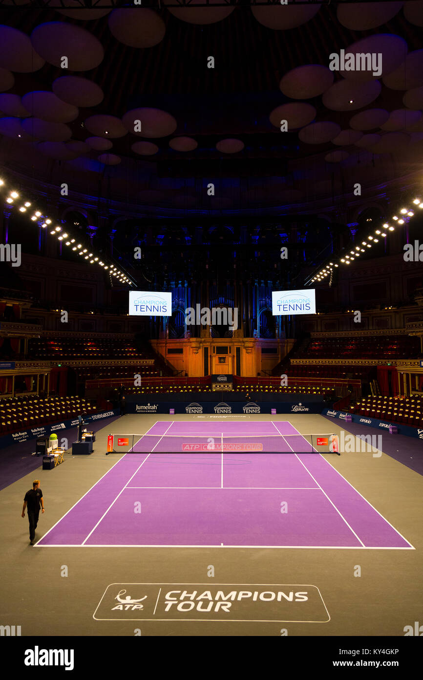 London, UK. A lone worker walks around the outside of the tennis court installed in the Royal Albert Hall for the Champions' Tennis tournament. Stock Photo