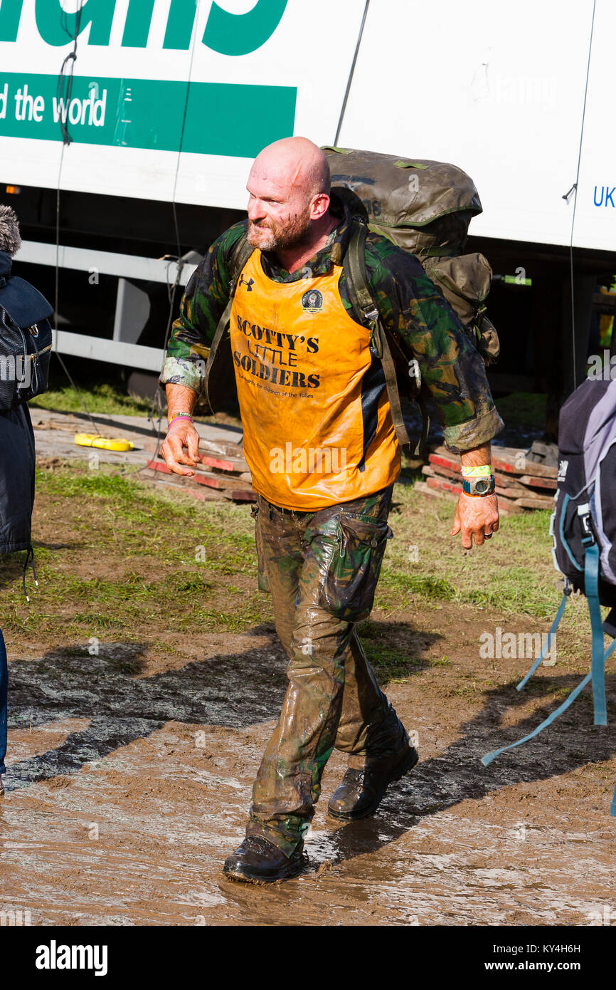 Sussex, UK. A man wearing army fatigues strides past during a Tough Mudder event. Stock Photo