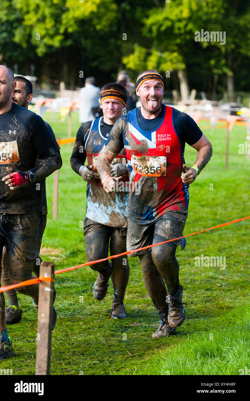 Sussex, UK. A man wearing a Help for Heroes outfit smiles and sticks out his tongue during a Tough Mudder event. Stock Photo