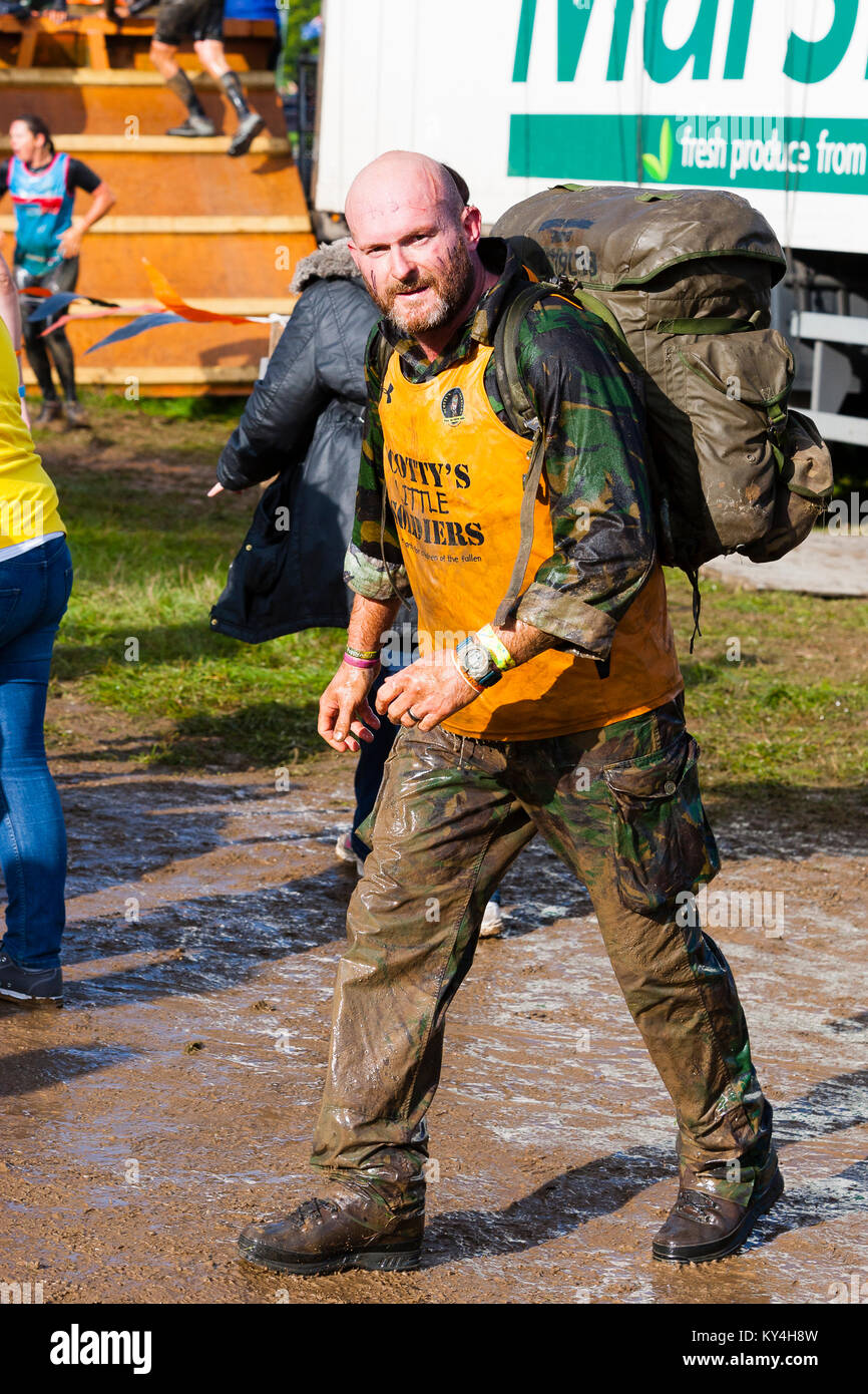 Sussex, UK. A man wearing army fatigues strides past during a Tough Mudder event. Stock Photo