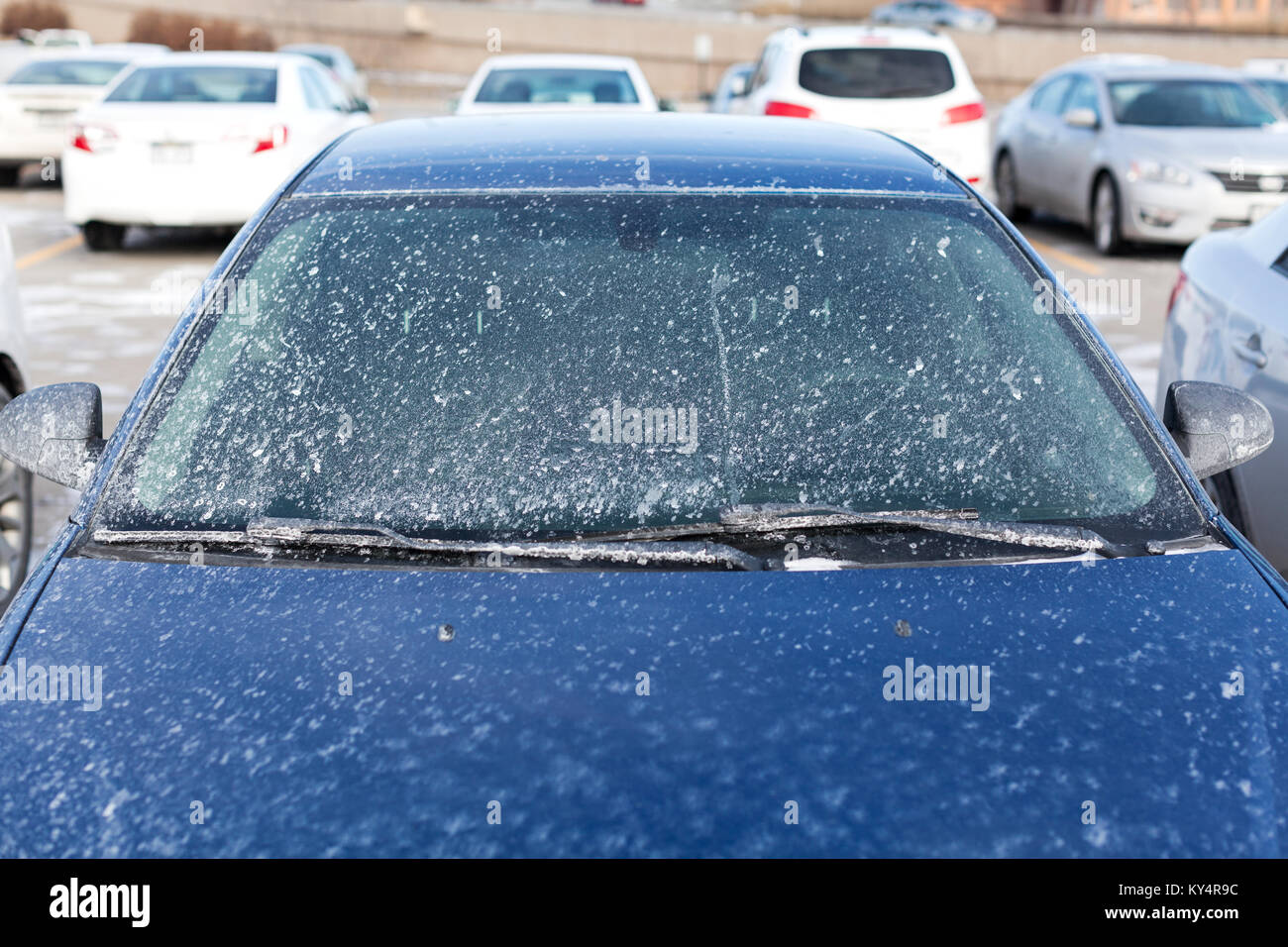 Salt grime splattered windscreen on blue car. Stock Photo