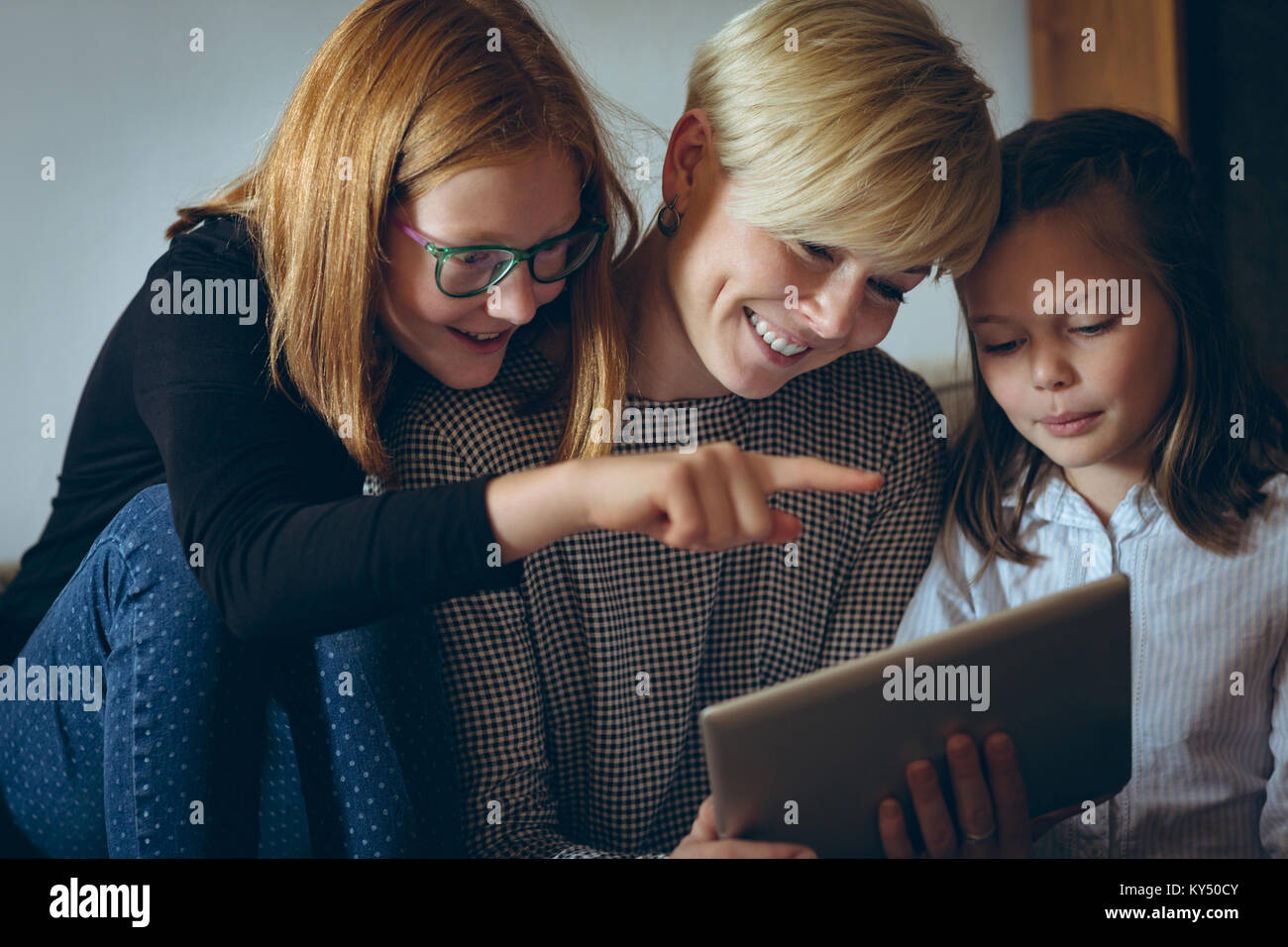 Mother and her kids using digital tablet at home Stock Photo