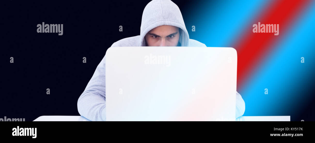 Serious burglar hacking into laptop Stock Photo