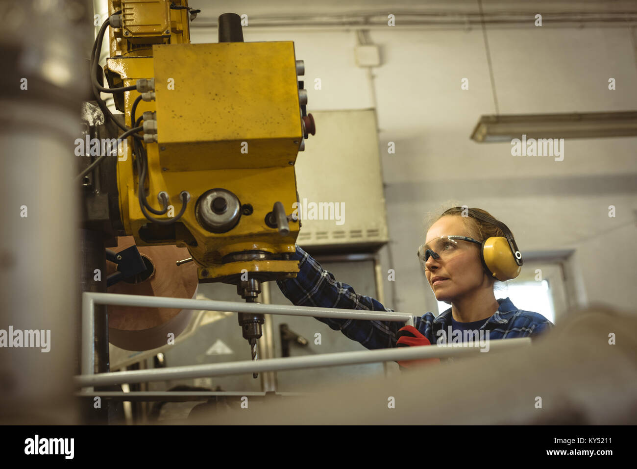 Female worker operating a machine Stock Photo - Alamy