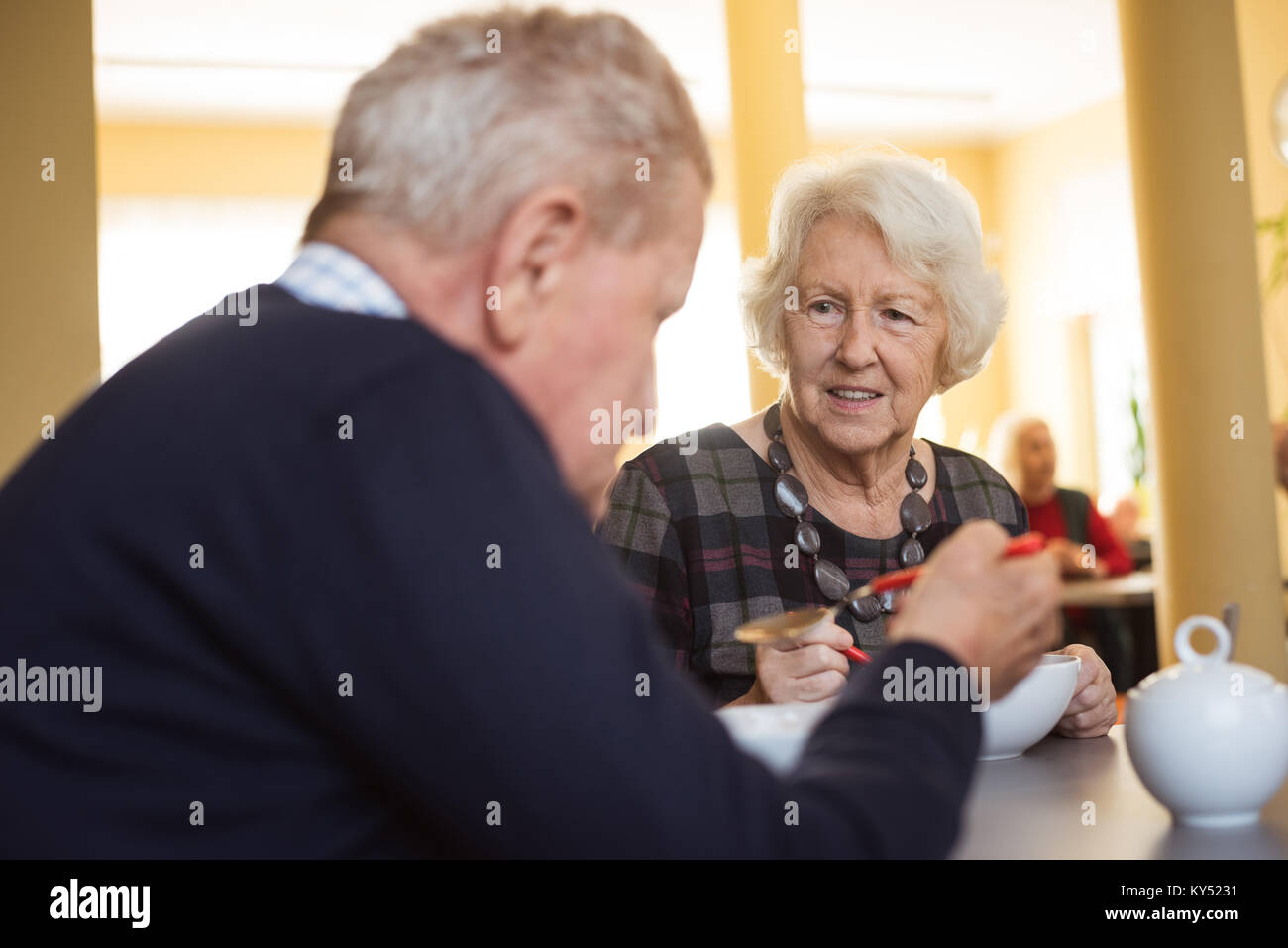 Senior friends interacting while having breakfast at nursing home Stock Photo