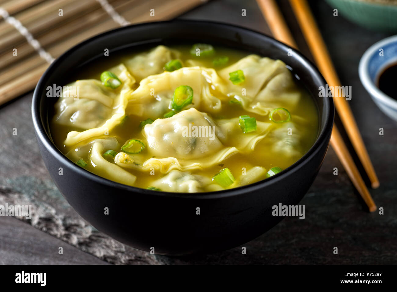 A bowl of delicious chinese wonton soup with green onion garnish. Stock Photo