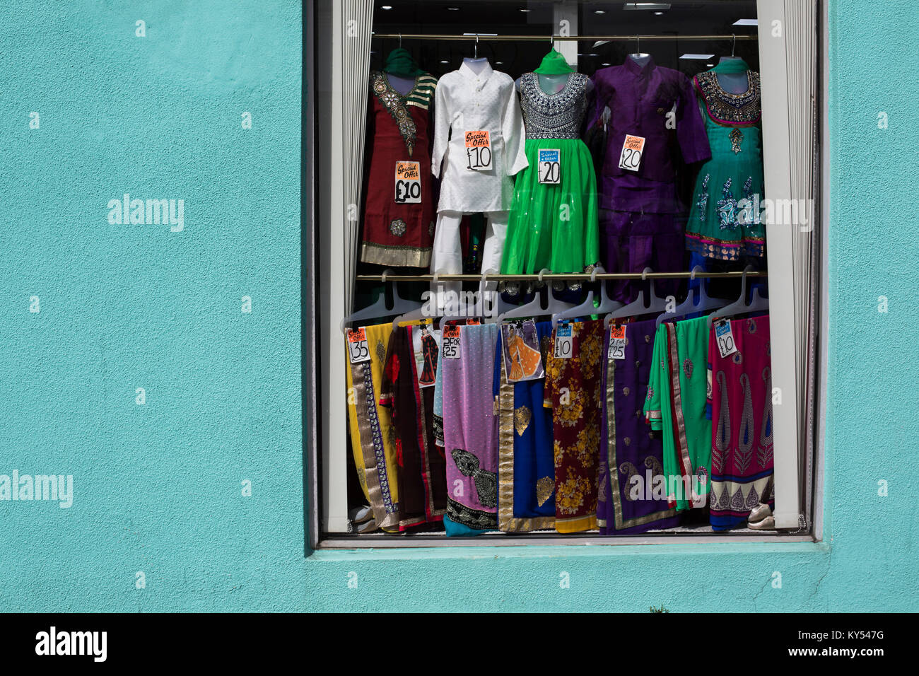 A window display of Saris in a shop in the Golden Mile district of the city of Leicester in the English Midlands. The district has one of the largest populations of people with an Indian background in the United Kingdom. The local football club, Leicester City, were on the brink of being surprise winners of the English Premier League in the 2015-16 season. Stock Photo