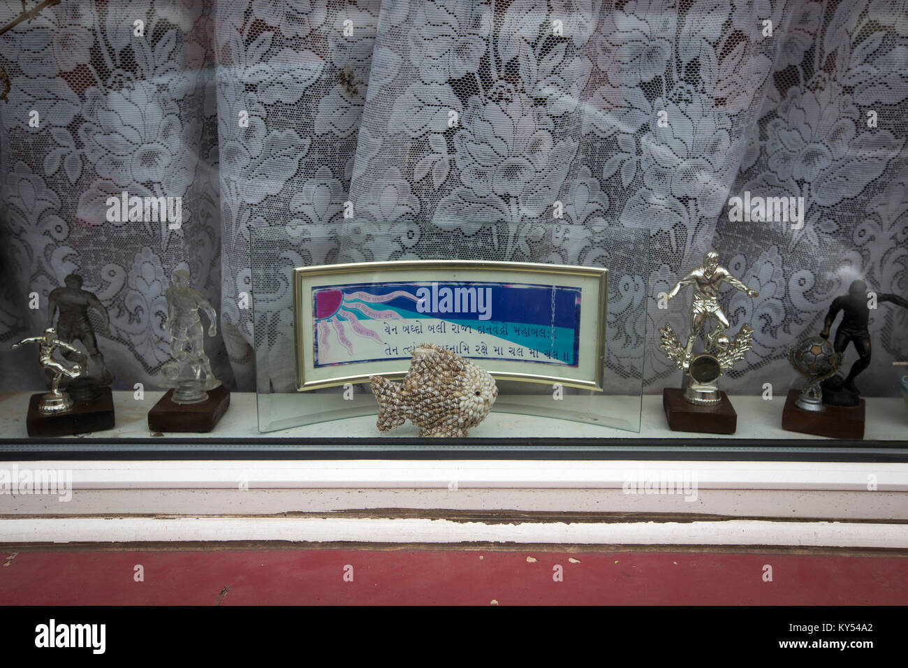 A window in a residential house decorated with Hindu symbols and sporting trophies in the Golden Mile district of the city of Leicester in the English Midlands. The district has one of the largest populations of people with an Indian background in the United Kingdom. The local football club, Leicester City, were on the brink of being surprise winners of the English Premier League in the 2015-16 season. Stock Photo