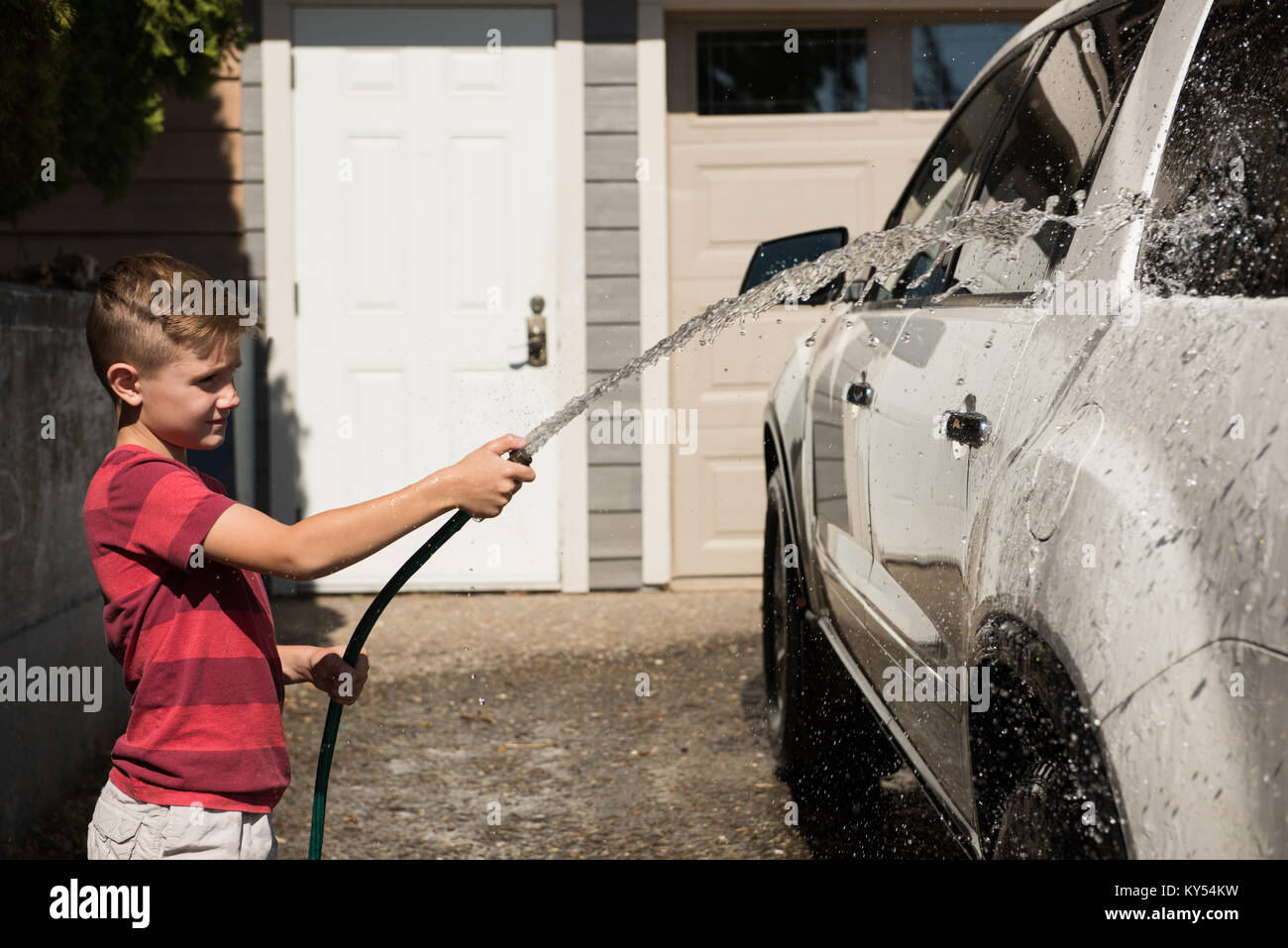 Boy washing a car at outside garage Stock Photo Alamy