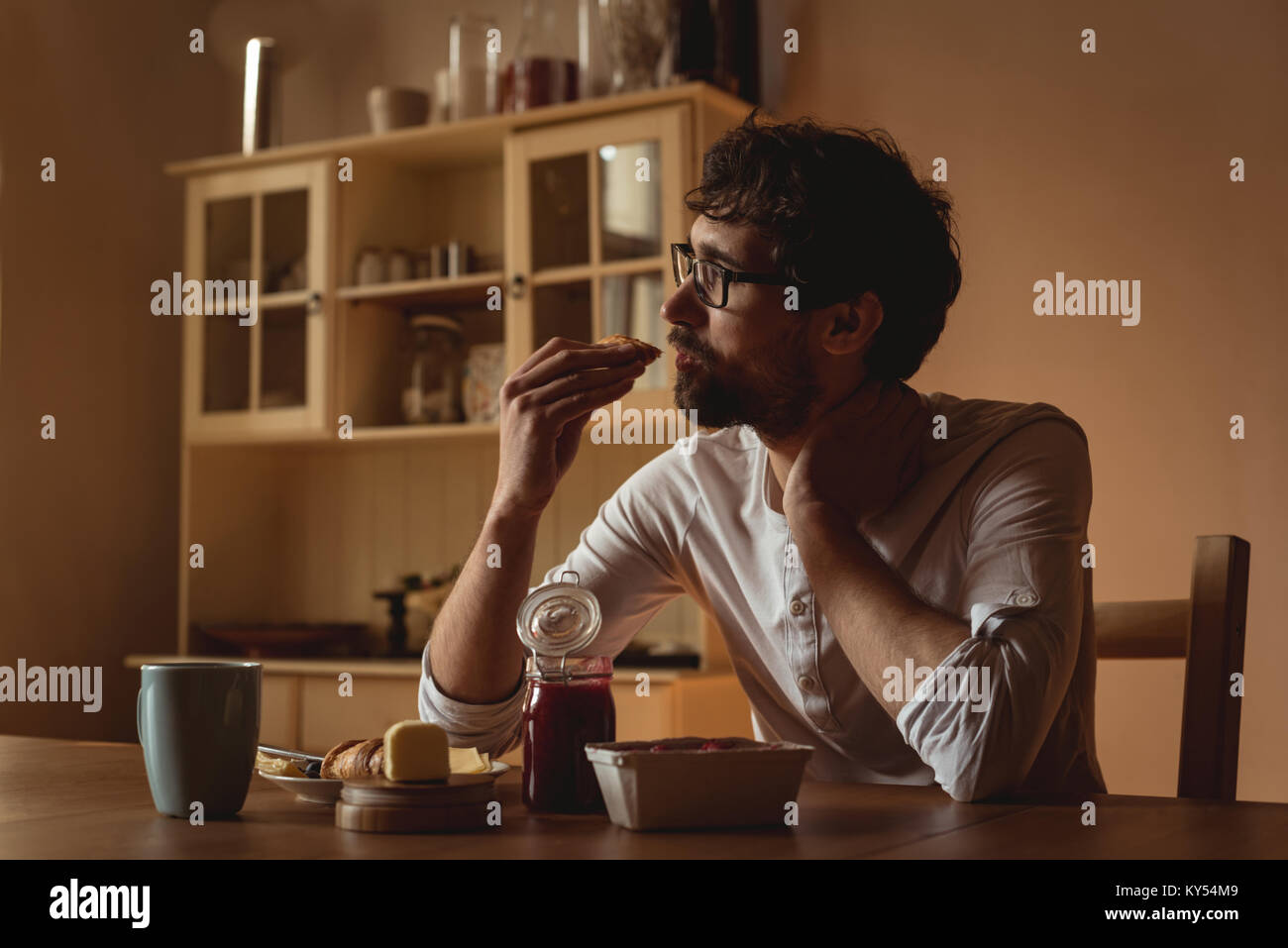 Thoughtful man having breakfast in kitchen Stock Photo