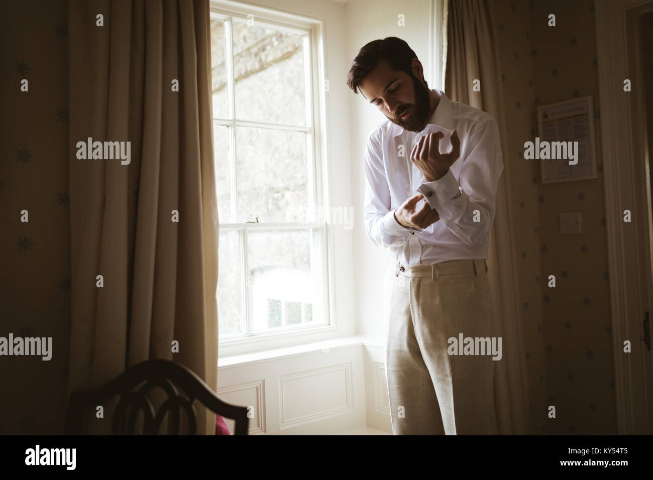 Groom getting dressed at home Stock Photo