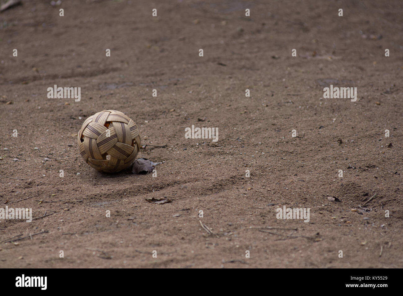 Sepak takraw kick volleyball ball alone on a dry dirt court. Stock Photo