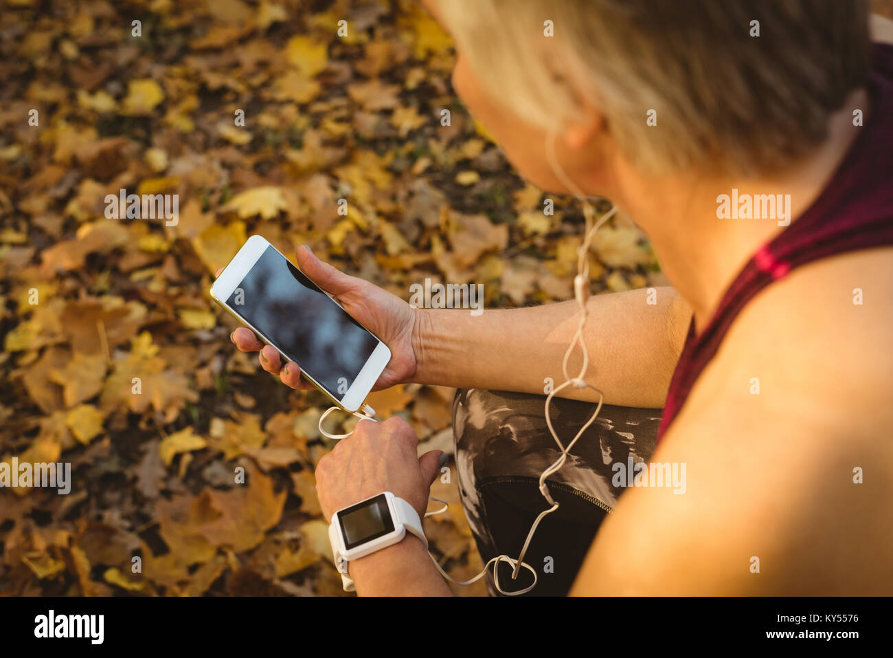 Senior woman listening to music in the park Stock Photo