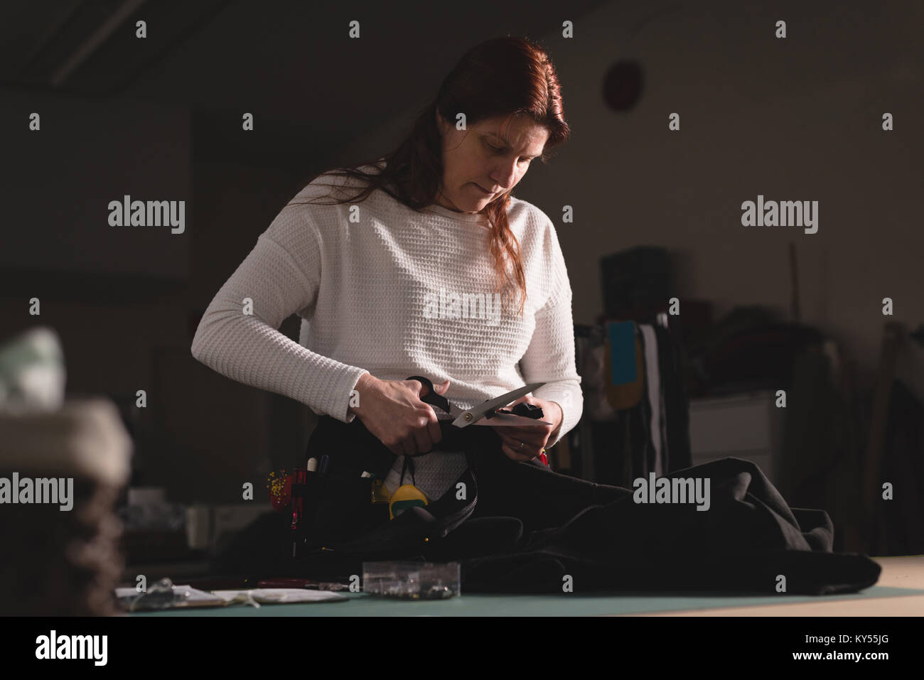 Tailor cutting clothes with scissors Stock Photo Alamy