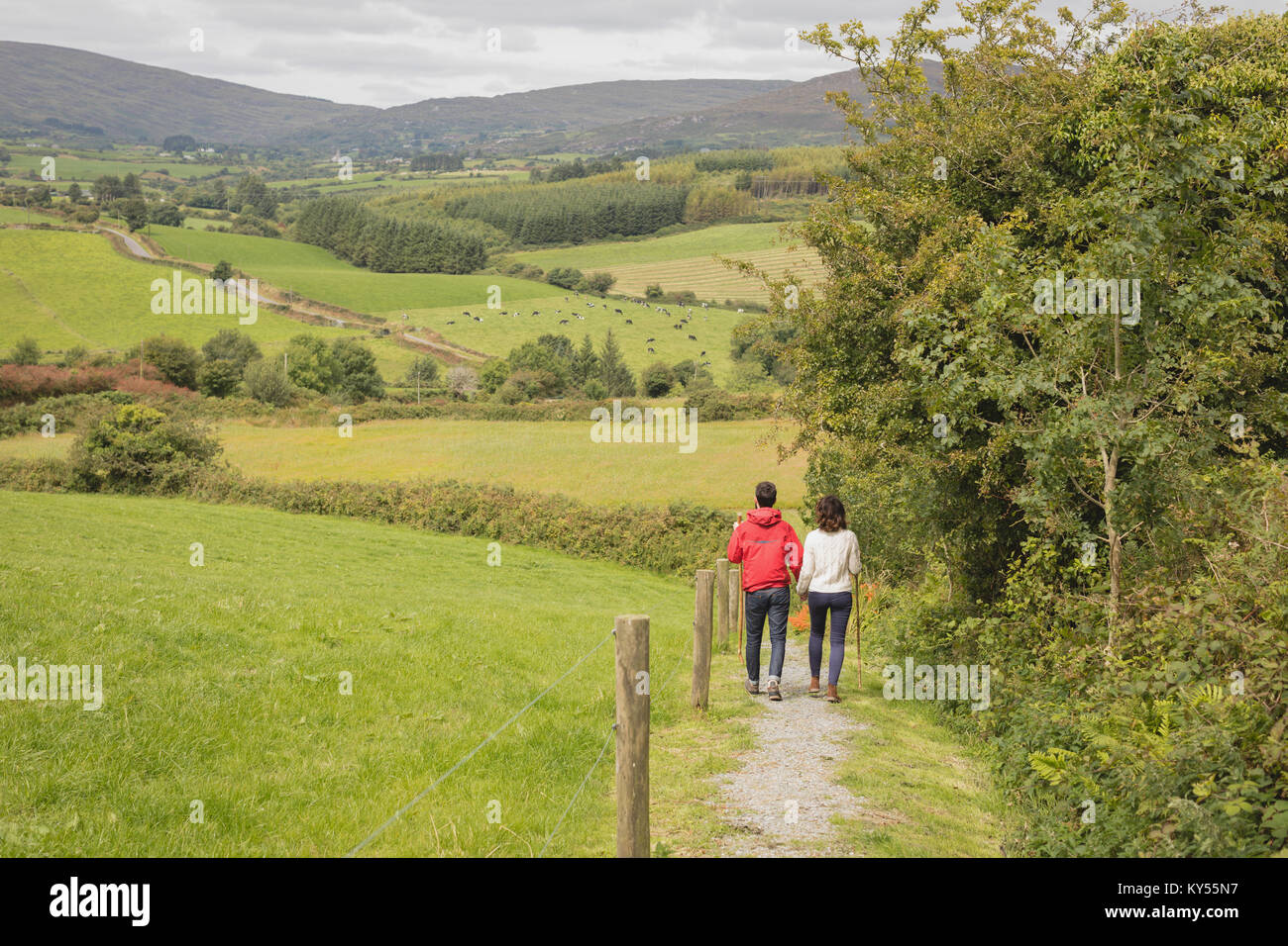 Rear view of couple walking on path Stock Photo - Alamy
