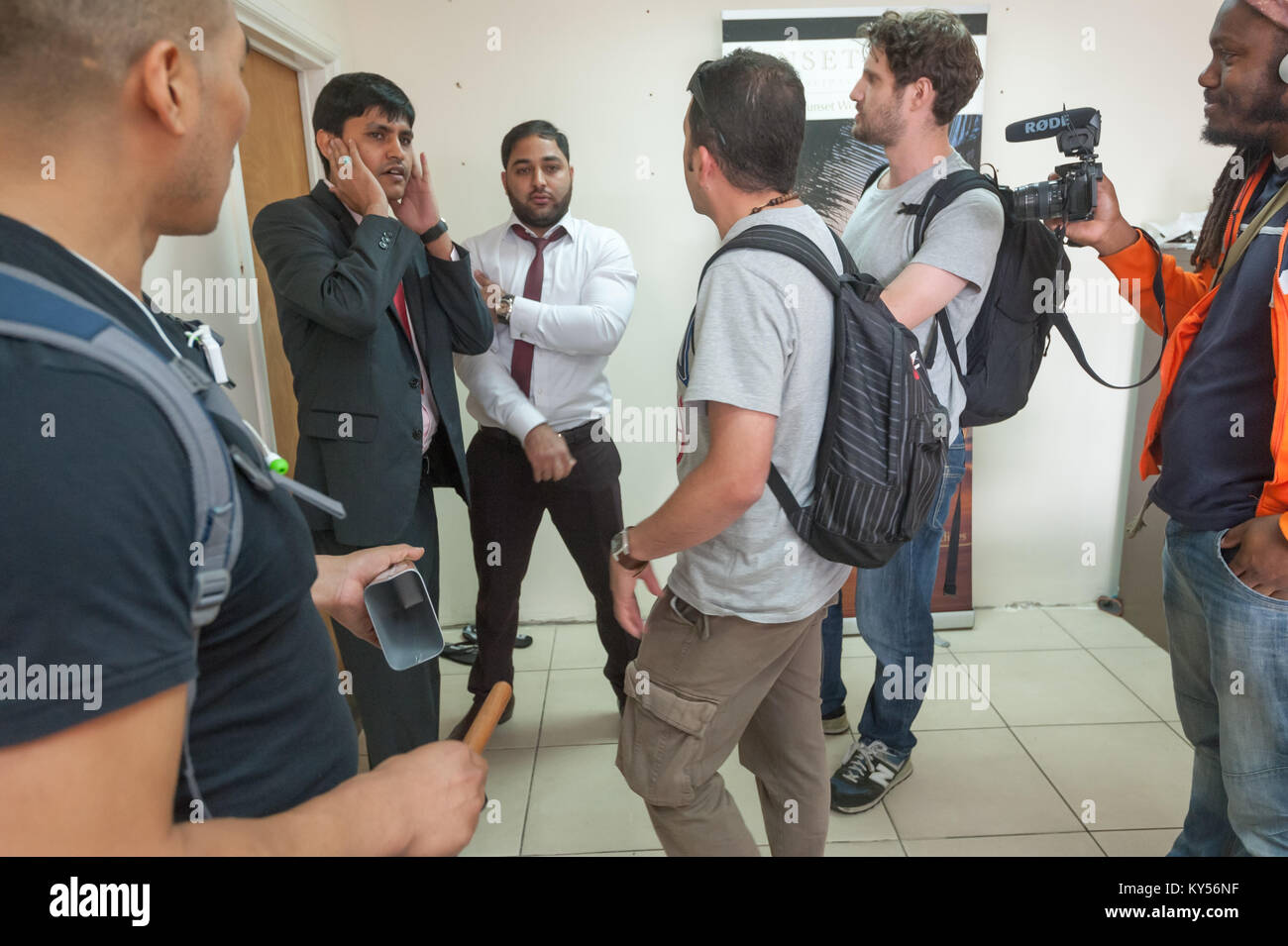 Usman Bhatti  (in white shirt) is confronted by UVW members outside the  door at the rear of the offices. His Hunter Home Properties Ltd has one desk at the front of these offices and has no connection to others working there. Stock Photo