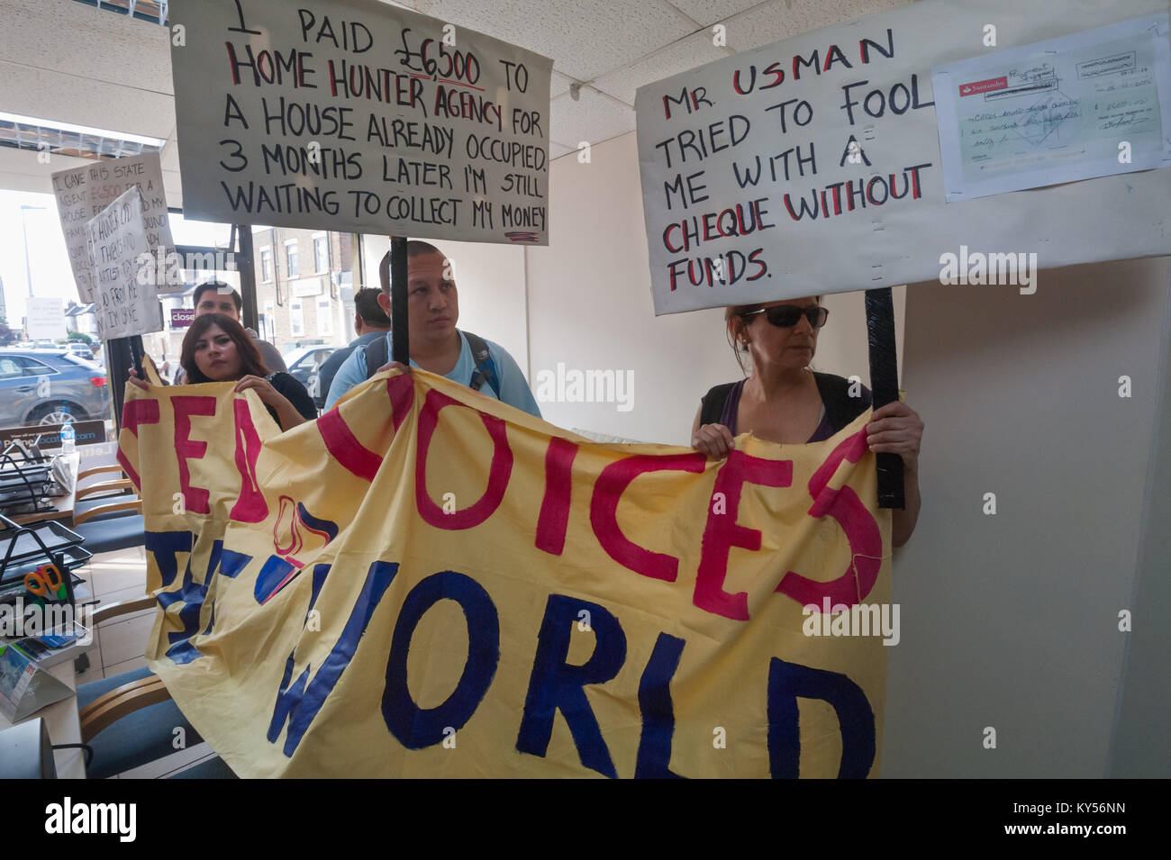 UVW members hold their banner and placards inside the office shared by Hunter Home Properties Ltd. Placards explain why they have come to demand the Usman Bhatti repays the remaining £5,500 he owes to Carlos. Stock Photo