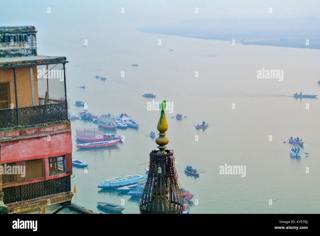 Varanasi, Uttar Pradesh, India, A landscape of the Ganges river with A green parrot perching on a roof Stock Photo
