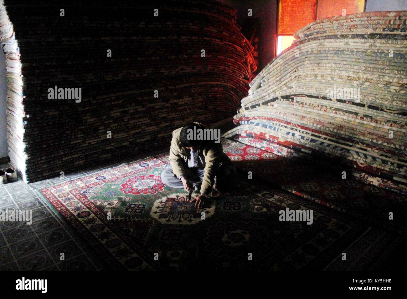 Peshawar. 13th Jan, 2018. A man crafts a carpet at a local carpet factory in northwest Pakistan's Peshawar on Jan. 13, 2018. The workers of carpet industry in Peshawar earn around 500 Pakistani rupees (less than 5 USD) per day for their livelihood. Credit: Saeed Ahmad/Xinhua/Alamy Live News Stock Photo