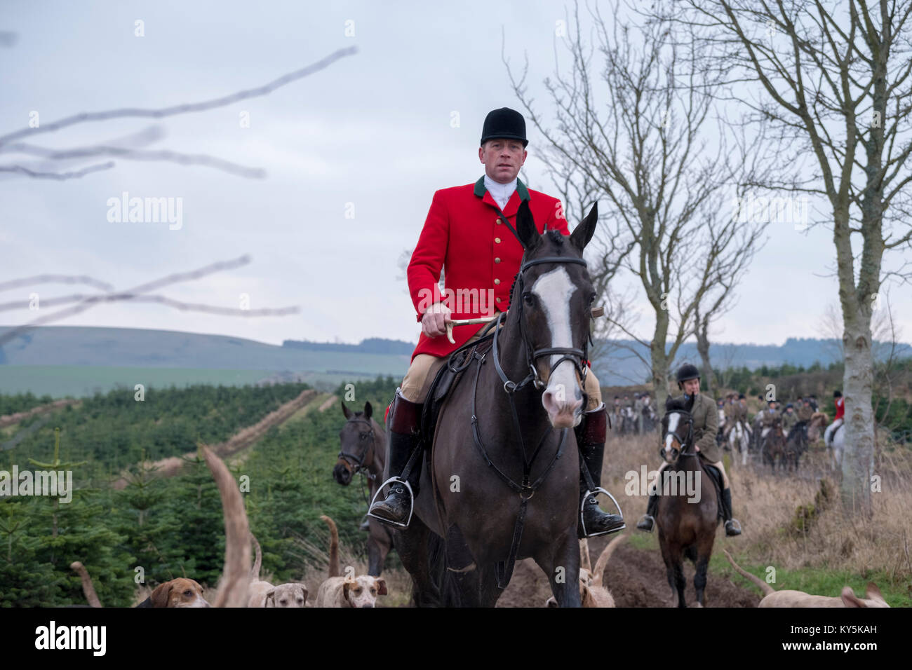 Ancrum, Rawflat /, UK. 13th January, 2018. Buccleuch Foxhounds at Rawflat, near Ancrum Caption: Huntsman Tim Allen (2014 - )(front red jacket) with the Duke of Buccleuch's Hunt Foxhounds on Saturday 13th January in the hills near to Ancrum, Jedburgh, a turnout of around 60 mounted supporters falling the days hunt. ( Credit: Rob Gray/Alamy Live News Stock Photo