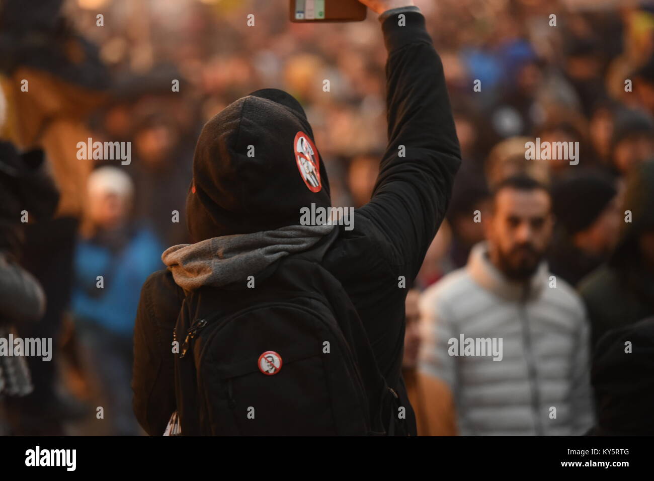 Vienna, Austria. 13th Jan, 2018. hooded protester takes a photo during an anti-government demonstration. Credit: Vincent Sufiyan/Alamy Live News Stock Photo