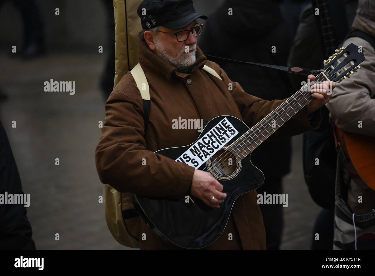 Vienna, Austria. 13th Jan, 2018. man playing guitar during an anti-government demonstration. the sticker reads 'this machine kills fascists'. Credit: Vincent Sufiyan/Alamy Live News Stock Photo