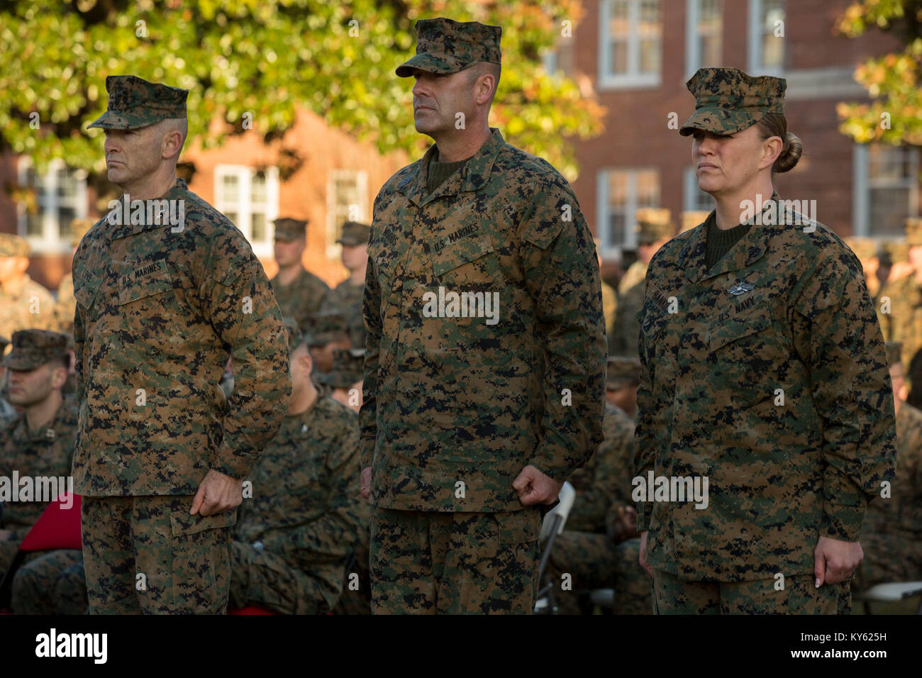 U.S. Marine Corps Maj. Gen. John K. Love, commanding general, 2nd Marine Division (2d MARDIV), left, Sgt. Maj. Michael P. Woods, sergeant major, 2d MARDIV, Senior Chief Petty Officer Jill Bankus stand at attention during a morning colors award ceremony on Camp Lejeune, N.C., Dec. 12, 2017. The ceremony is held to honor colors as well as award Marines and Sailors. (U.S. Marine Corps Stock Photo