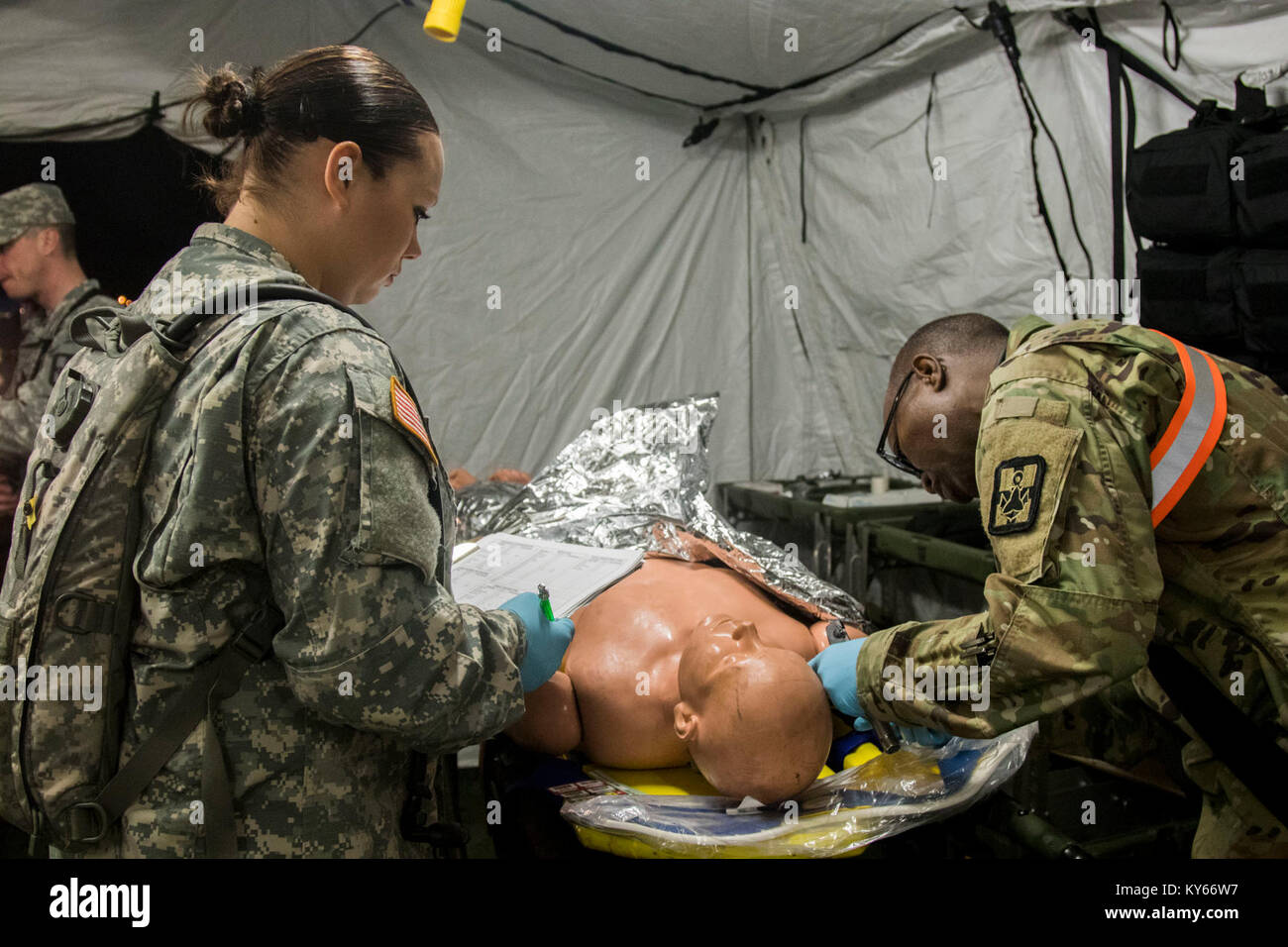 U.S. Army Soldier exanime simulated casualties during a Mass Casualty Decontamination exercise at the Homestead-Miami Speedway, in Miami-Dade, Florida, Jan. 9, 2018. This is the 3rd in a series of joint training exercises between Active Duty, Guard, and Reserve Army units and local municipalities across the United States. This JTE focused on the decontamination and transportation of casualties in a simulated mass chemical attack. (DoD Stock Photo