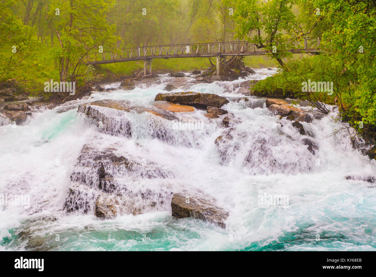 Travel, beauty in nature. Small bridge and waterfall torrential river along the Aurlandsfjellet mountains in Norway Sogn og Fjordane, foggy hazy summe Stock Photo
