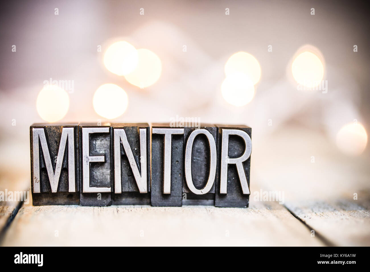 The word MENTOR written in vintage metal letterpress type on a bokeh light and wooden background Photo - Alamy