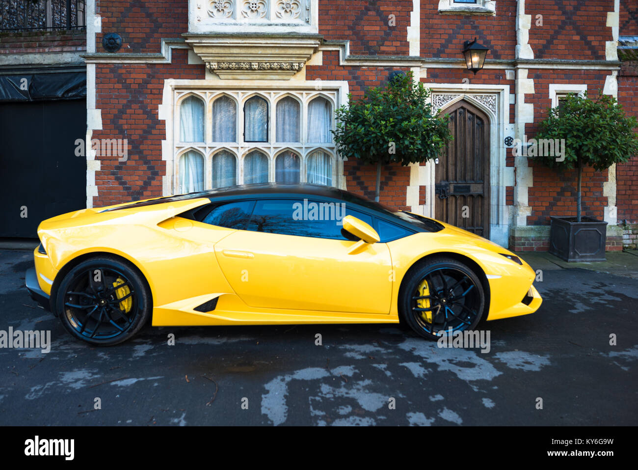 Yellow Lamborghini parked outside grand old house on Chequer Square next to the Norman tower & facing the Great churchyard, Bury St. Edmunds, Suffolk, Stock Photo