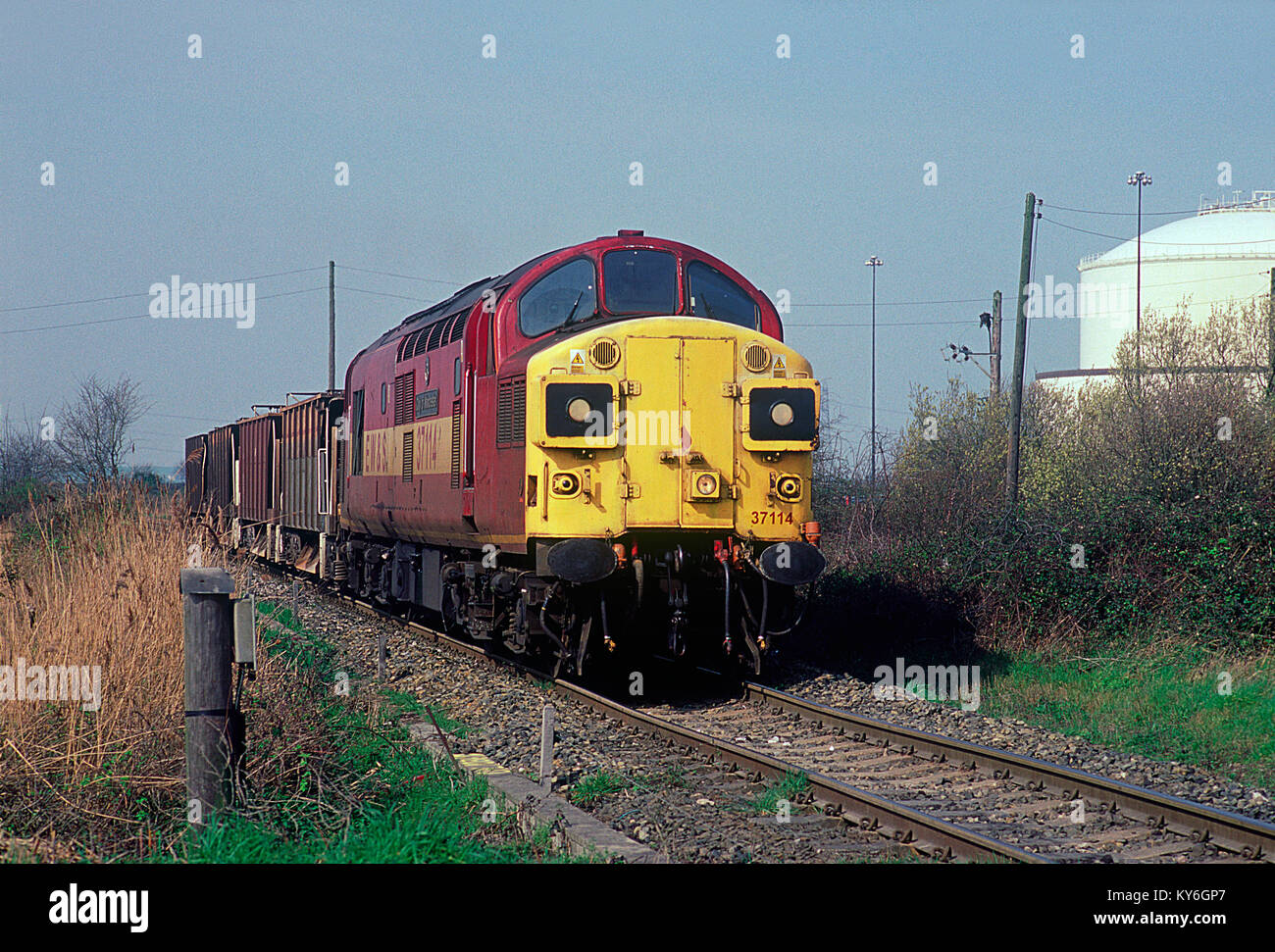 A class 37 diesel locomotive number 37114 working a train of empty ballast wagons approaching Grain Crossing on the Grain branch in Kent. 25th March 2002. Stock Photo