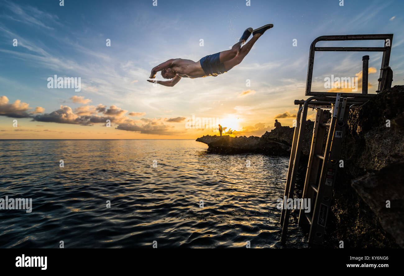 SAN ANDRES ISLAND, Colombia   Circa March 2017. Person Jumping down a little Volcanic Rock Cliff into the Caribbean Sea of San Andres during a Beautif Stock Photo