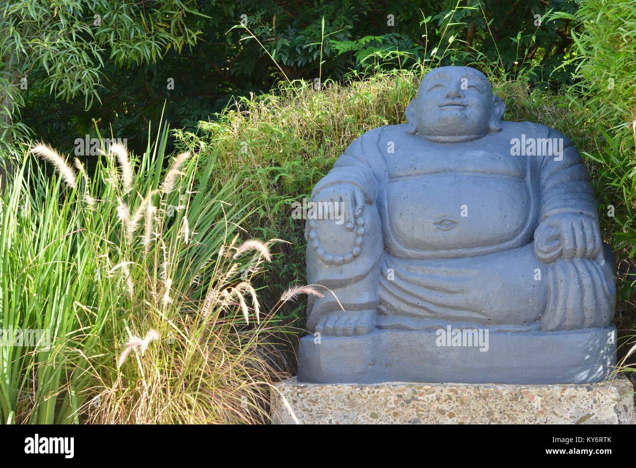 Large concrete buddha statue art piece in a suburban garden hires stock photography and images
