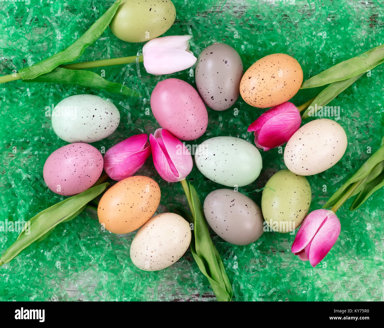 colorful eggs and tulips on artificial green grass for Easter ...