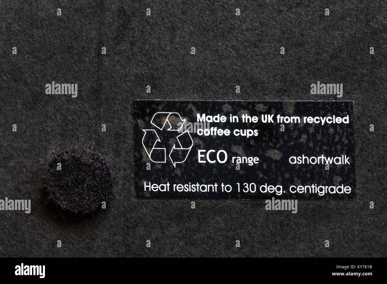 label on back of black place mat coaster - made in the UK from recycled coffee cups ECO range - disposal recycling recycle logo symbol Stock Photo