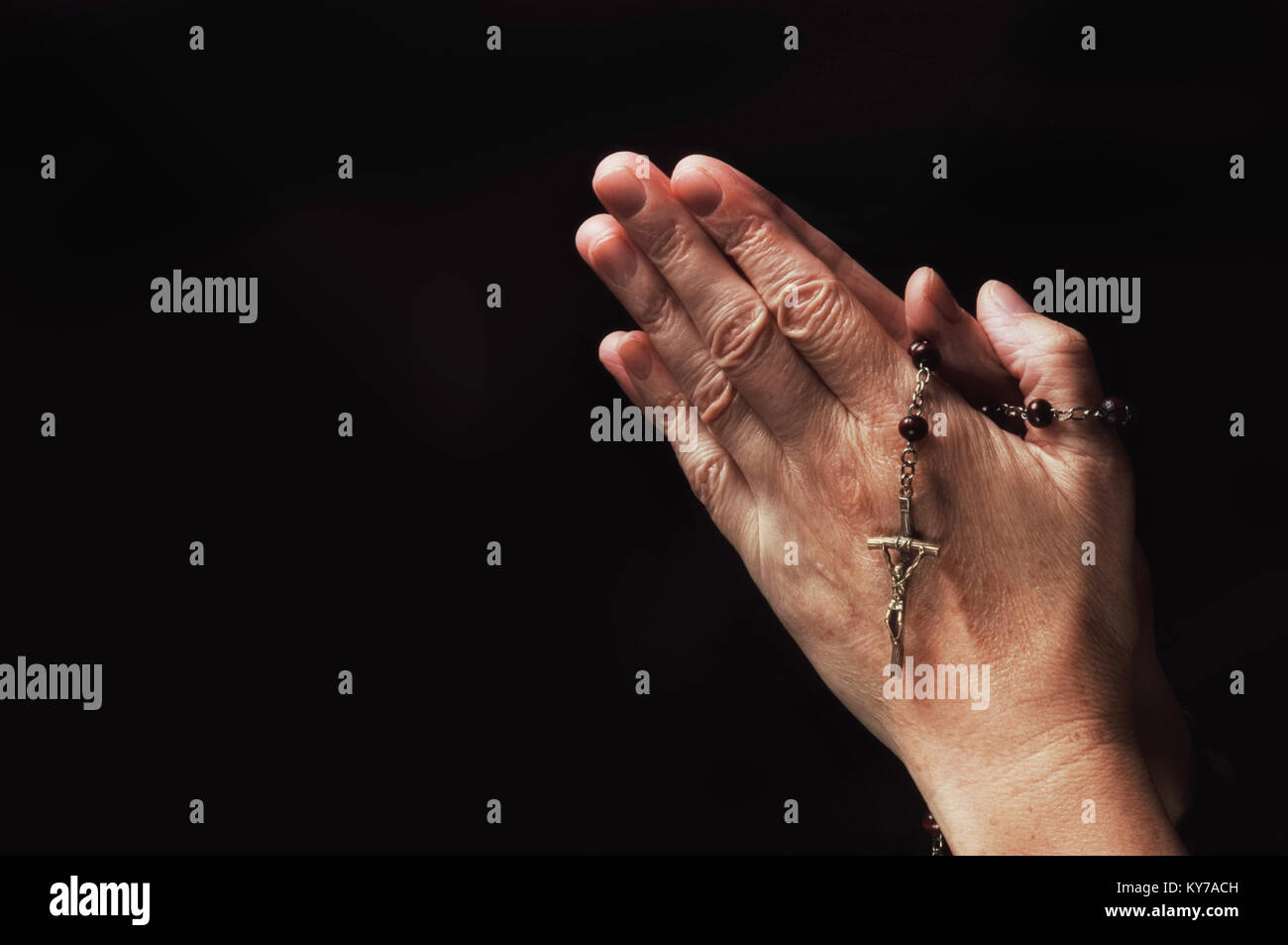 Close-up of a female hand holding rosary beads and a crucifix - John Gollop Stock Photo