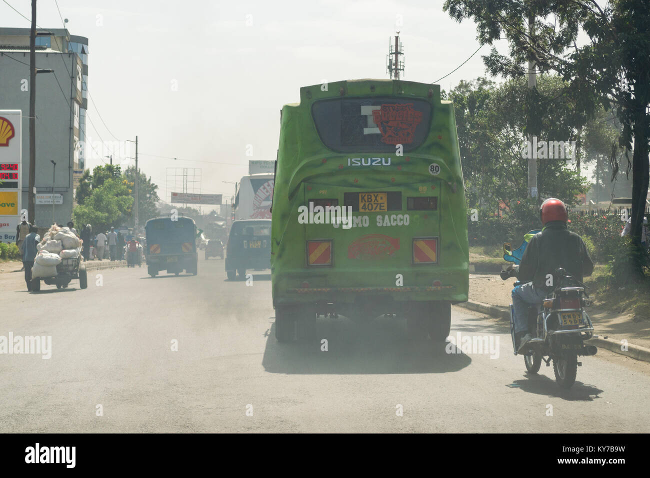 A bus drives along a road spewing a large amount of exhaust fumes in to the air, Nairobi, Kenya, East Africa Stock Photo