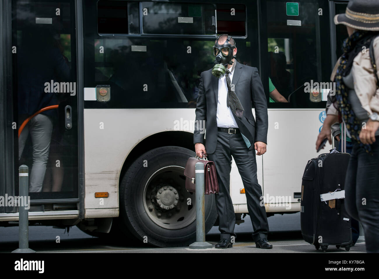 Businessman in a bus station wearing a gas mask on the face Stock Photo -  Alamy