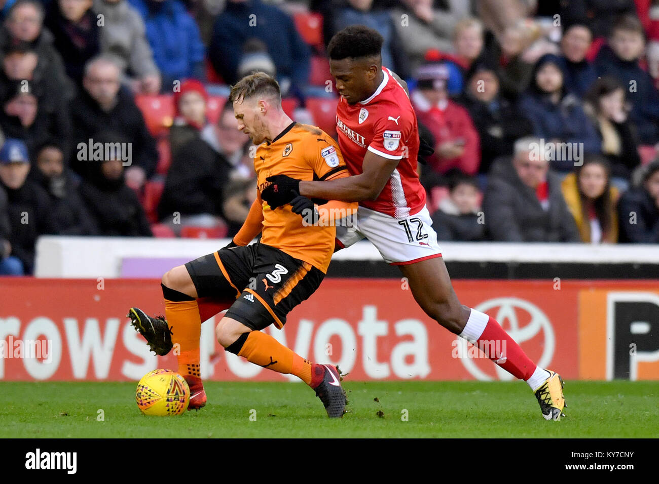 Wolverhampton Wanderers' Barry Douglas (left) and Barnsley's Dimitri Cavare compete for possession during the Sky Bet Championship match at Oakwell, Barnsley. Stock Photo