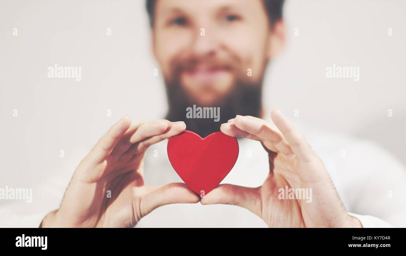 Bearded man hands holding Heart shape Love symbol Valentines Day romantic greeting lifestyle feelings concept Stock Photo