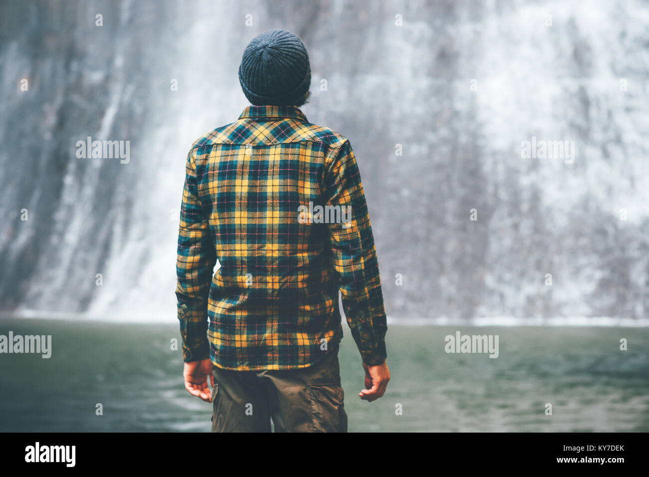 Man looking at waterfall Travel Lifestyle adventure concept vacations into the wild Stock Photo