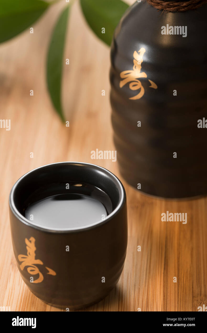 Japanese Sake Rice Wine In Black And Gold Cups With Sakiebottle On A Bamboo Background Stock Photo Alamy