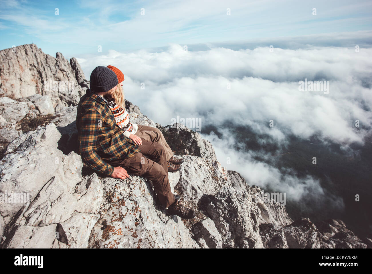 Couple travelers Man and Woman sitting on mountains cliff relaxing over ...