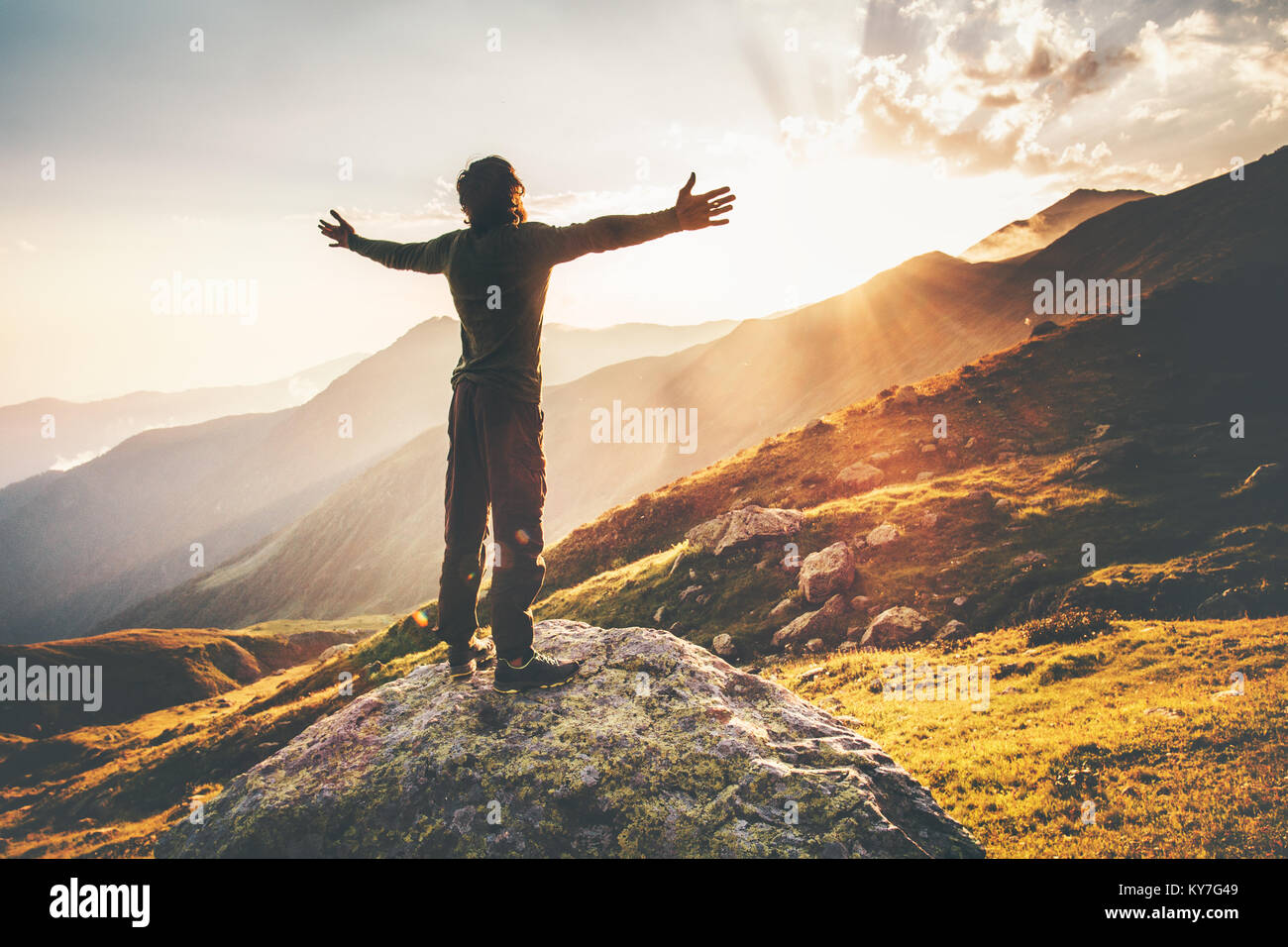 Happy Man raised hands at sunset mountains Travel Lifestyle emotional concept adventure summer vacations outdoor hiking mountaineering harmony with na Stock Photo
