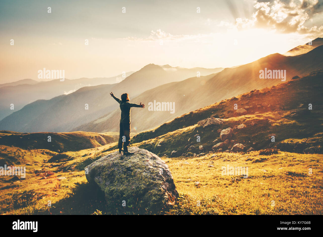 Man raised hands at sunset mountains Travel Lifestyle success and wellness emotional concept adventure vacations outdoor hiking harmony with nature ae Stock Photo