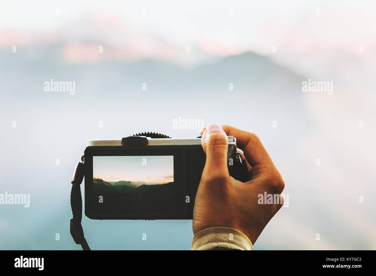 Hand with photo camera taking shot of mountains landscape outdoor Travel Lifestyle adventure summer vacations Stock Photo